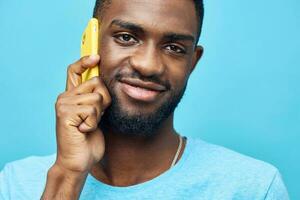 uomo nero Telefono africano giovane mobile mostrando tecnologia Sorridi contento blu sfondo foto