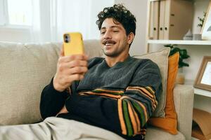 Messaggio uomo casa Telefono libero professionista moderno divano divano tecnologia comunicazione stile di vita digitando foto