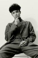 uomo fumo fiducia mano ritratto fricchettone alunno riflessivo nero maschio e sigaretta moda seduta casuale bianca foto