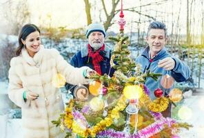 famiglia che decora l'albero di Natale foto