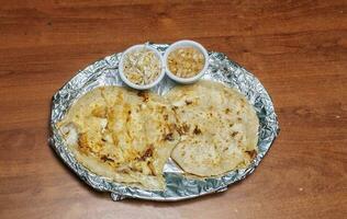 Due nicaraguense pupusas servito con insalata su il tavolo. delizioso salvadoregno pupusas con fuso formaggio servito su il tavolo. tradizionale pupusas servito con insalata su il tavolo foto