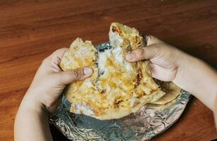 mani demarcazione delizioso nicaraguense pupusa su il tavolo, Visualizza di mani demarcazione delizioso salvadoregno pupusas su di legno tavolo. concetto di tradizionale fatto a mano pupusas foto