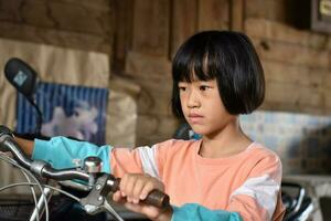 bambino asiatico ragazza con bicicletta, Vintage ▾ tonica foto