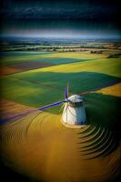 un aereo Visualizza di un' mulino a vento nel il mezzo di un' campo. ai generato foto