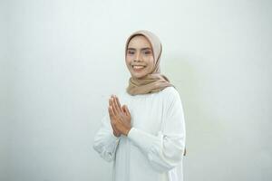 sorridente giovane asiatico musulmano donna Esprimere a gesti eid mubarak saluto isolato al di sopra di bianca sfondo foto