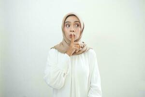 bellissimo giovane asiatico musulmano donna indossare casuale Abiti chiede per essere silenzioso con dito su labbra. silenzio e segreto concetto. foto