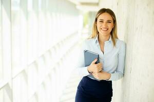 giovane attività commerciale donna Tenere con taccuino nel il ufficio corridoio foto