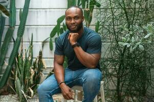 contento africano americano uomo sorridente nel Giardino dietro la casa a casa foto