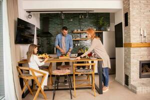 giovane famiglia preparazione verdure nel il cucina foto