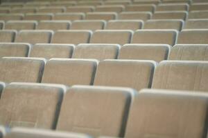 un' riga di vuoto beige sedie nel il auditorium. foto