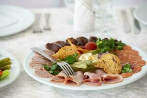 su un' piatto, un aperitivo di affettato carne con crostini e verdure. foto