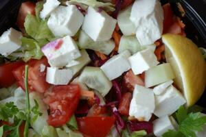 Close up di insalata greca in una ciotola sul tavolo. foto