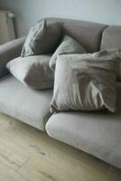 moderno grigio divano con cuscini nel vivente camera a casa foto