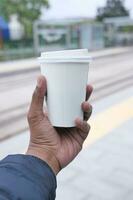 mano Tenere un' prendere lontano kraft caffè tazza foto