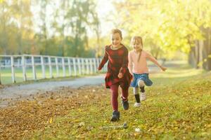 Due poco ragazze nel autunno parco foto