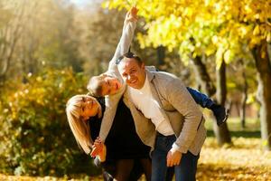 famiglia giocando nel autunno parco avendo divertimento foto