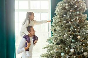 contento giovane padre e il suo figlia a casa con Natale albero foto