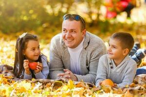 carino famiglia nel un' parco su un giorno d'autunno foto