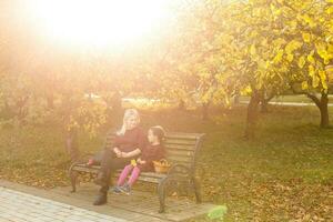 madre e figlia su un' panchina nel autunno parco foto