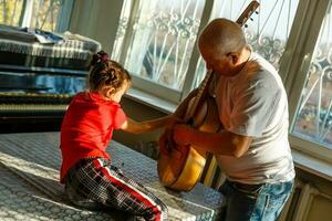 avvicinamento dell'uomo mano mutevole stringhe su il suo vecchio acustico chitarra. foto