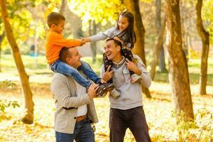 contento padri e bambini avendo divertimento all'aperto nel frutteto giardino, giocando insieme foto