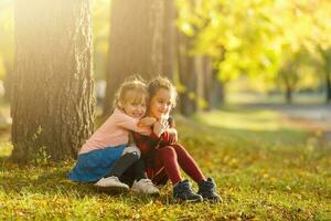 Due poco ragazze nel autunno parco foto