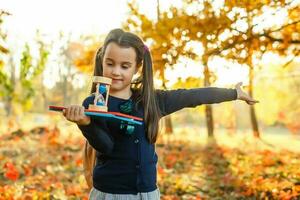 poco scolara vicino il scuola. prescolastico bambino con un' zaino su il suo primo giorno a scuola o asilo. indietro per scuola. bambino formazione scolastica. autunno foto