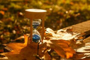 autunno tempo tema, clessidra su caduto le foglie nel vario colori con copia spazio. foto