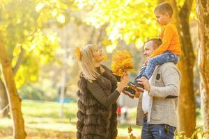 famiglia giocando nel autunno parco avendo divertimento foto