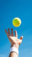 mano di un' uomo lancio tennis sfera. ai generato foto