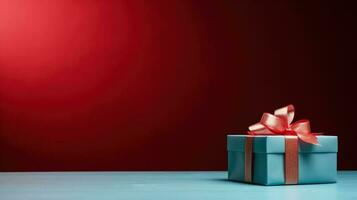 regalo scatola su un' blu tavolo su un' vivido rosso sfondo con vuoto spazio per testo foto