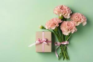 superiore Visualizza di rosa presente scatole con nastro, garofano fiori su un' morbido pastello verde sfondo con copia spazio, generativo ai foto