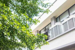 aria condizionatore caldo unità con verde albero natura per Salvataggio energia casa energia consumo aria condizionata costo. foto