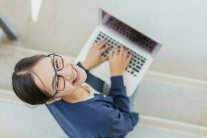 Università giovane adolescente ragazza contento sorridente godere utilizzando il computer portatile per apprendimento formazione scolastica nel scuola città universitaria. foto