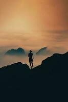 donna corre nel silhouette attraverso il montagne foto