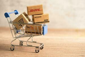 bangkok, Tailandia settembre 26, 2022 shopping carrello con dhl amazon e fedex esprimere Imballaggio scatola, importare esportare in linea scambio investimento attività commerciale. foto