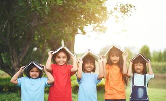 vicino su di ragazza bambino amici nel un' parco sorridente per telecamera foto