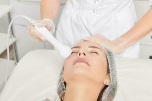 cosmetologo fa rf sollevamento per ringiovanimento donna viso, anti invecchiamento cosmetico procedura foto