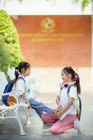 indietro per scuola. carino poco ragazza gentilezza cravatte lacci delle scarpe per un' amico. foto