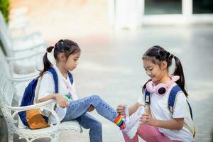 indietro per scuola. carino poco ragazza gentilezza cravatte lacci delle scarpe per un' amico. foto