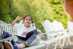 indietro per scuola. asiatico ragazza lettura un' libro. primario scuola studenti dopo classi apprendimento compiti a casa. foto