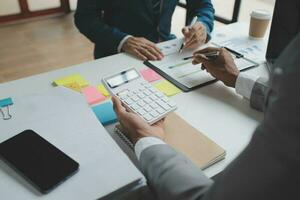 gli analisti finanziari analizzano i rapporti finanziari aziendali su un progetto di investimento di pianificazione di un tablet digitale durante una discussione in una riunione aziendale che mostra i risultati del loro lavoro di squadra di successo. foto