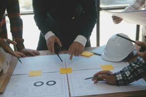 costruzione e struttura concetto di ingegnere o architetto incontro per progetto Lavorando con compagno e ingegneria utensili su modello edificio e planimetria nel Lavorando luogo, contrarre per tutti e due aziende. foto