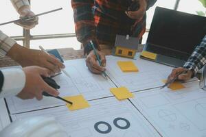 costruzione e struttura concetto di ingegnere o architetto incontro per progetto Lavorando con compagno e ingegneria utensili su modello edificio e planimetria nel Lavorando luogo, contrarre per tutti e due aziende. foto