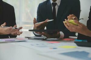 gli analisti finanziari analizzano i rapporti finanziari aziendali su un progetto di investimento di pianificazione di un tablet digitale durante una discussione in una riunione aziendale che mostra i risultati del loro lavoro di squadra di successo. foto