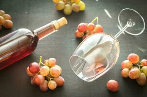 bicchiere di rosa vino con mazzo di uva foto