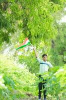 indiano ragazzo Tenere nazionale bandiera nel azienda agricola, contento ragazzo, nazionale bandiera foto