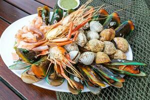 frutti di mare gamberi gamberi cozze vongole su piatto e buio sfondo cotto cibo foto