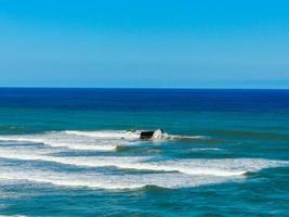 le onde si infrangono sulla spiaggia di muriwai, auckland, in nuova zelanda