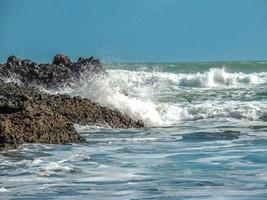 le onde si infrangono sulla spiaggia di piha, auckland, in nuova zelanda